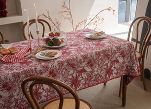 Detail of red jacquard tablecloth with pom-pom fringe and French jungle pattern