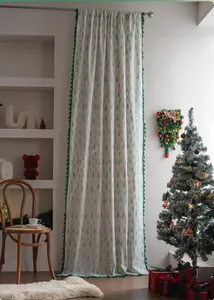 Detail of Christmas curtain featuring green pine tree prints and decorative pom-pom trim