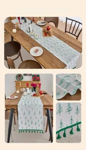 Detailed view of Christmas table runner with green tree prints and decorative tassels