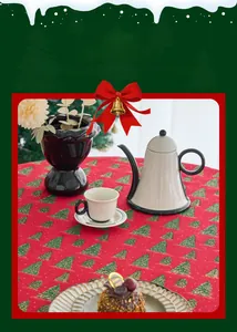 Detail of red Christmas tablecloth featuring green pine tree prints on a festive dinner table