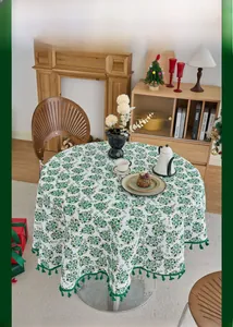 Detail of round Christmas tablecloth with pine needle print and green tassel fringe trim