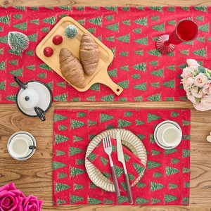 Detailed flat lay of red Christmas table runner and mats with gold glitter tree patterns