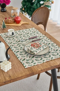Detailed view of linen Christmas table runner and napkin with pine leaf and berry prints