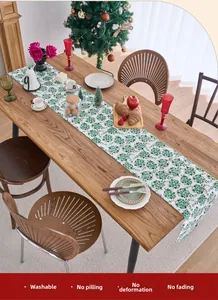 Washable Christmas table runner with green snowflake patterns on white fabric detail