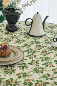Detailed pattern of holly leaves and red berries on a Christmas holiday tablecloth