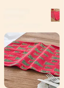 Detailed view of red Christmas table runner featuring green and gold glitter tree patterns