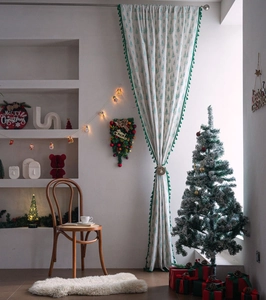 Detail of Christmas curtain featuring green tree prints and elegant fringe tassel trim