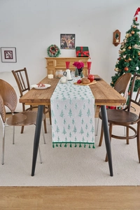 Detail of Christmas table runner with green pine prints and elegant fringe tassels