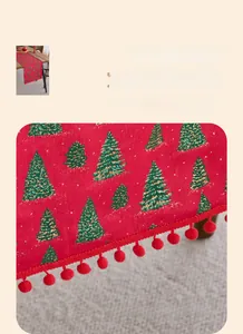 Detailed view of Christmas table runner with green gold trees and red pompom fringe
