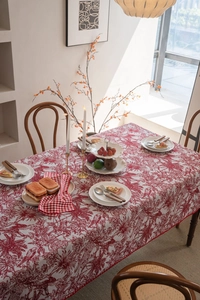 Detail showing red floral patterns and bird motifs on rustic rectangular tablecloth