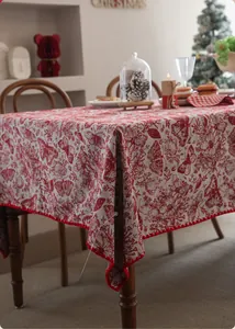 Close-up of red and beige butterfly floral tablecloth with decorative pom-pom fringe