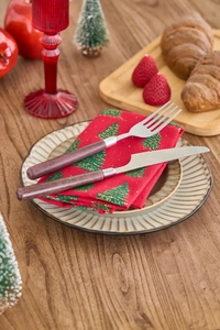 Close-up of stainless steel cutlery with wood grain handles on Christmas napkins