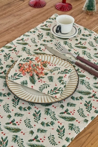 Detailed view of Christmas cloth napkin and placemat with green holly and red berry prints