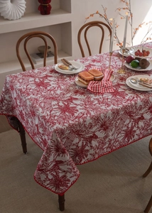 Detailed close-up of red and white Toile de Jouy tablecloth with elegant scalloped edges