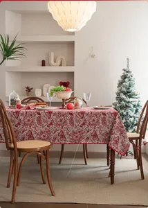 Detail of red and white jacquard Christmas tablecloth with floral patterns and wavy edges