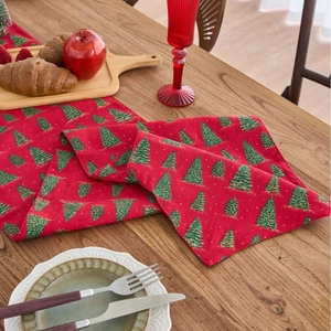Festive red Christmas table runner with green tree patterns and golden glitter on wood