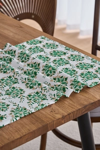 Dettaglio del runner da tavola rustico con stampe floreali verdi e motivi dorati festosi