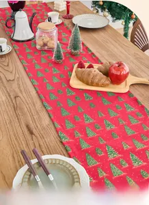 Close-up of red Christmas table runner with gold-stamped green tree patterns