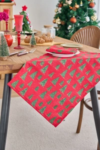 Detail of red festive table runner featuring green Christmas tree patterns and gold accents