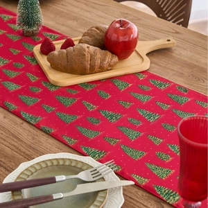 Christmas red table runner featuring green tree patterns on a rustic wooden dining table