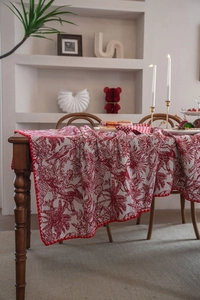 Detail of red and white jacquard tablecloth featuring vintage woodland bird patterns