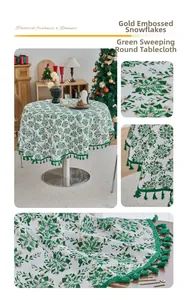 Detail of round tablecloth featuring golden snowflower pattern and green tassel trim