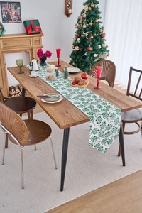 Detail of Christmas table runner with green botanical prints on rustic wooden dining table