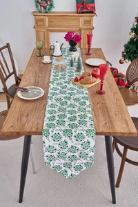 Detailed Christmas table runner with gold snowflake patterns on white fabric