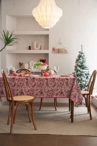 Detailed close-up of red and white Christmas tablecloth featuring butterfly floral patterns