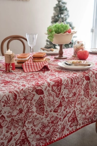 Detail of festive red jacquard tablecloth with butterfly patterns and pom-pom fringe edges