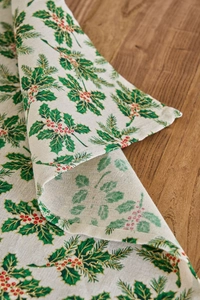 Detailed close-up of festive Christmas holly leaves and red berries on cloth