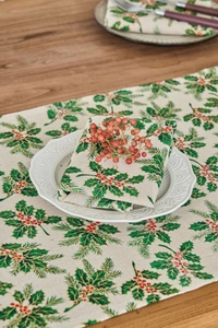 Christmas cloth napkins with holly and berry prints on a rustic wooden table setting