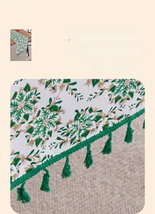 Close-up of green and gold botanical print table runner with reinforced edges and tassels
