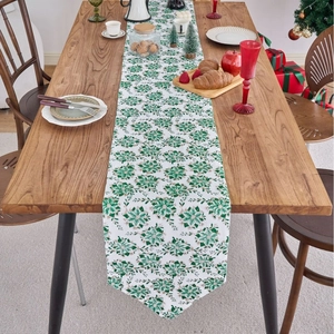 Christmas table runner with green and gold floral pattern on white linen fabric