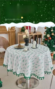 Detail of round Christmas tablecloth with pine tree prints and green tassel edges