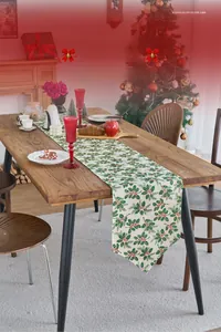 Close-up of Christmas table runner with holly leaf prints and elegant tassel details