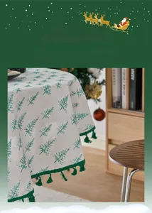 Detail of Christmas tablecloth with green pine tree prints and decorative tassels