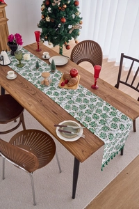 Detail of Christmas table runner with green tassels and gold snowflake prints
