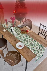 Detailed handcrafted tassel table runner featuring festive holly and red berry prints