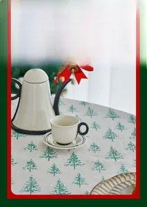 Detail of Christmas tablecloth with green pine tree pattern and festive table setting