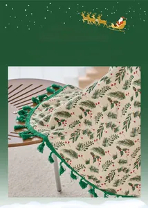 Detailed view of Christmas pine needle print tablecloth with green tassels on wooden table