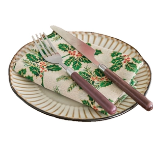Christmas dinner napkins with green holly leaves print and rustic stainless steel cutlery set