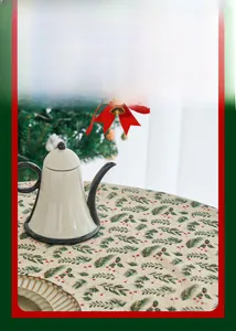 Detail of Christmas tablecloth with green pine needles and red berries on beige fabric