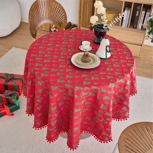 Red Christmas tablecloth with green pine patterns and festive pom-pom trim decorations
