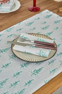 Detailed view of linen napkins with green pine tree prints for Christmas table settings