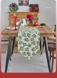 Detail of Christmas table runner with holly berry pattern on rustic wooden table