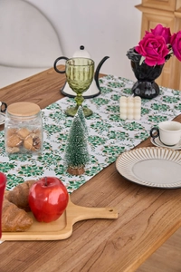 Detail of green snowflake patterns on white table runner in a festive setting