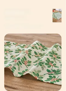 Close-up of Christmas table runner fabric with holly leaves and berry print texture