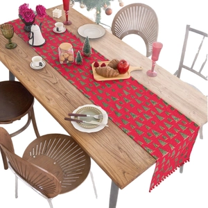 Christmas table runner with red base, green tree patterns and pom-pom tassel decor
