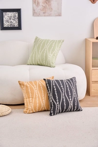 Detailed view of floral wave pattern cushion covers in green, yellow, and charcoal grey